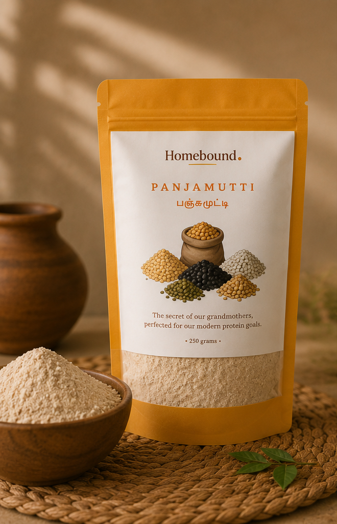 Homebound Panjamutti protein powder in a yellow stand-up pouch with a white label, styled on a woven mat with a wooden bowl of powder and a clay pot in the background.